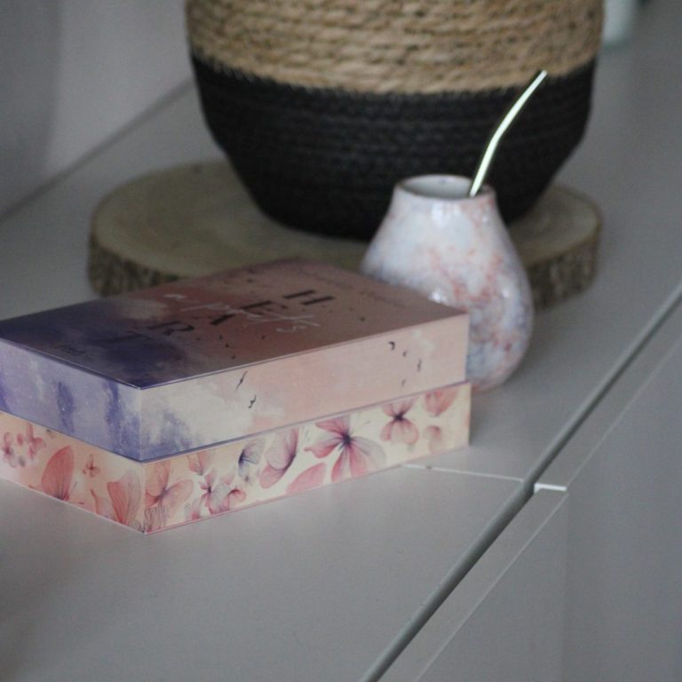 Ich freue mich auf deine Nachricht Bunte Box und eine kleine, gefächerte Vase auf einer hellen Oberfläche.